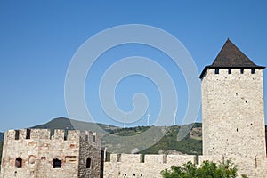 Romanian Wind Farm with Wind Turbine and windmills facing an old castle located on the Serbian side of the Danube river