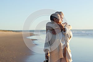 Romanic senior couple spending time at seashore at sunset