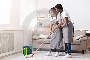 Romantic African Couple Cleaning Flat Together, Mopping Floor And Embracing