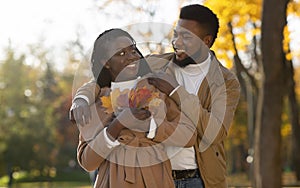 Romantic african couple hugging at date in autumn park