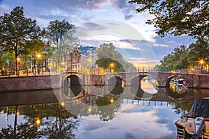 Romantic Amsterdam.  Famous view of Amsterdam at dawn. Downtownr. The lanterns are still on, but the sun has already colored the
