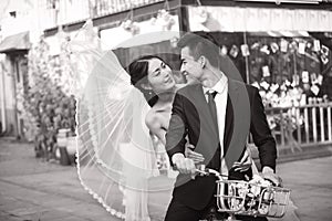 Romantic asian newly-wed riding a bicycle