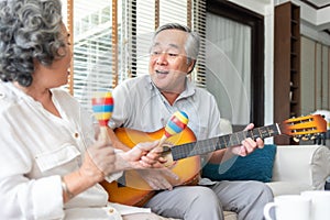 Romantic Asian senior Couple playing acoustic guitar