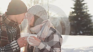 The romantic atmosphere and dreams come true create an emotional video of a young couple holding cups of hot warming