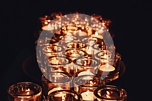 Romantic atmosphere, many small, lit candles on the table. Dark background