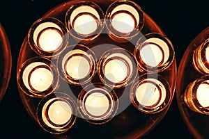 Romantic atmosphere, many small, lit candles on the table. Dark background