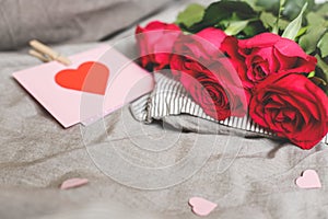 Romantic background with copy space. Beautiful roses and Valentine card with heart. Selective focus