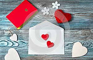 Romantic background with hearts, envelope, notebook on wooden background.