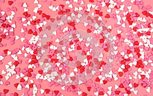 Romantic background with small hearts on pink background. The view from the top.