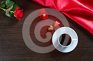 Romantic background with wedding ring, rose flowers, cup of coffee and chocolate candy