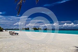 Romantic beach scenery with sunbeds on the Maldives