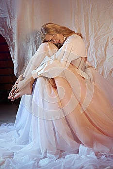 Romantic Beautiful blonde woman in white shirt and beige skirt with corset, curly hair. Delicate natural makeup, blue eyes, new