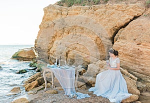 Romantic beautiful bride in luxury dress posing on the beach