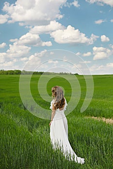 Romantic beautiful bride on sunny summer day outdoors. Young blonde woman in a beautiful wedding dress is running across