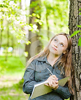 Romantic beautiful girl writes love poems on nature