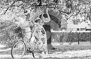 Romantic bike ride. Girl long dress retro cruiser bicycle sakura tree. Spring holidays. Tourism concept. Transportation