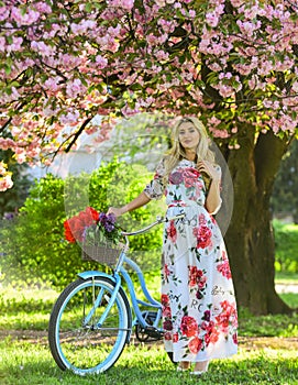 Romantic bike ride. Spring holidays. Tourism concept. Transportation and travel. Sakura season. Woman with tulips