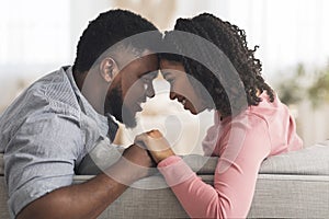 Romantic Black Couple Bonding At Home, Holding Hands And Touching Foreheads