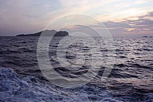 Romantic blue sunset between the waves of the Mediterranean sea and the islets of Ibiza on the horizon