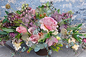 Romantic bouquet of beautiful flowers near old grunge wall