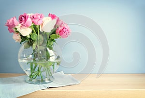 romantic bouquet of pink roses in the vase over wooden table