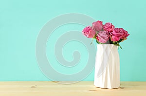 romantic bouquet of pink roses in the vase over wooden table.