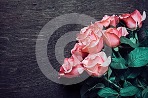 Romantic bouquet of tender pink roses on dark wooden background