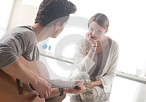 Romantic boy playing guitar for her girlfriend