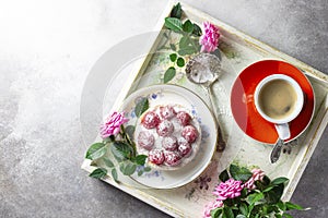 Romantic breakfast in bed, cup of coffee espresso with , tray with raspberry cake, and pink rose. Good morning concept