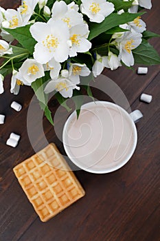 Romantic breakfast. Bouquet of jasmine. A cup of hot coca in spring. Top view, selective focus.