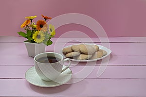 Romantic breakfast of coffee and delicious biscuits. Pink wooden background, selective focus