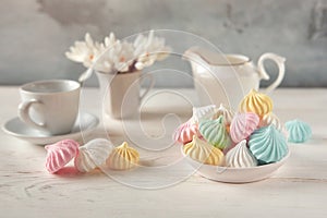 Romantic Breakfast with a Cup of tea, Crocus flowers and sweet multi-colored meringue on the wooden table