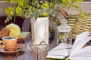 Romantic breakfast with fresh tea rye bread cheese and herbs, wild flowers on terrace of cottage