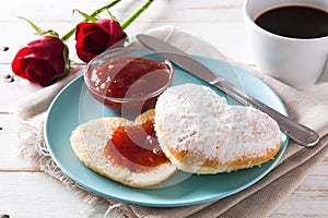 Romantic breakfast with heart-shaped bun,coffee, berry jam and roses