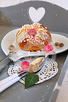 Romantic breakfast: sweet French bun on gray tray with heart
