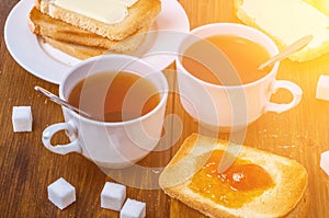Romantic breakfast for two with cup of hot tea and cherry jam with toasted bread and butter
