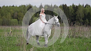 romantic bride is walking on horseback at wedding day, romantic view of woman and white horse