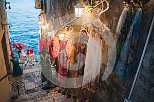 Romantic cafe table decorated with flowers at the shore in a narrow street in Rovinj, Croatia