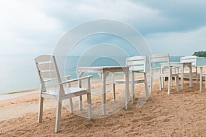 Romantic cafe with white tables and chairs on the sea shore