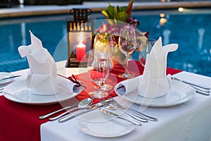 Romantic Candlelit Dinner Table; Poolside with Table Set. photo