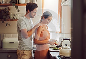 Romantic, caring and loving young couple supporting each other while preparing a meal in the kitchen. Man and woman in a photo