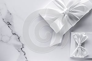 Luxury wedding gifts with silk bow and ribbons on marble background