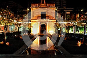 Romantic and charming scenery of the chapel of the port of Malaga seen by night. Historical landmark on Paseo de la farola street photo