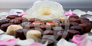 Romantic chocolate truffles and white roses heart shape setup horizontal
