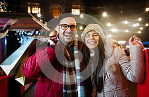 Romantic Christmas shopping. Happy young couple buying gifts for family. Sale and people concept.