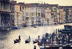 Romantic city of venice at sunset with three gondoliers on water