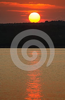 Romantic colorful sunset with water reflection