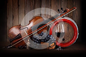 Composition with red grape, wine, violin and barrel