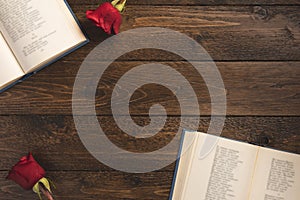 Romantic concept. Open books with poems and roses, on wooden background.