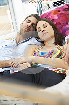 Romantic Couple Asleep In Garden Hammock Together